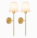 A symmetrical set of two stately Adler brass sconces featuring substantial metalwork and refined linen shades, showcasing a clean architectural silhouette against a crisp white background.