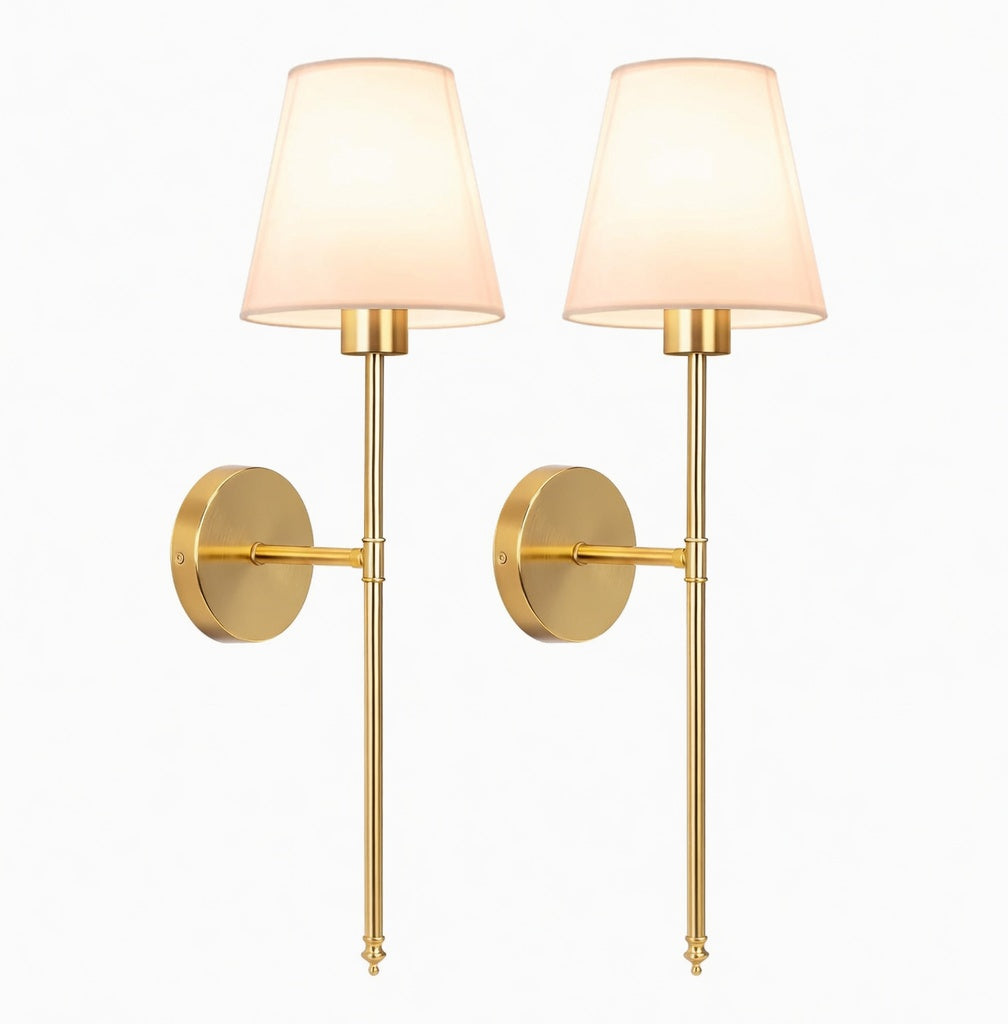 A symmetrical set of two stately Adler brass sconces featuring substantial metalwork and refined linen shades, showcasing a clean architectural silhouette against a crisp white background.