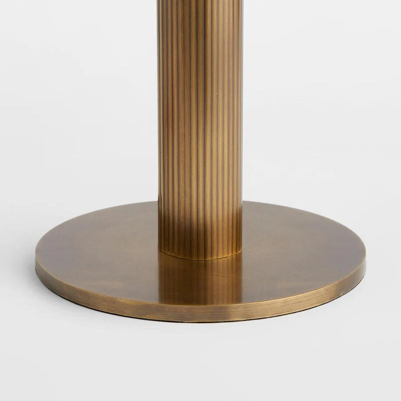 Close-up of the heavily weighted brass foundation with architectural fluting and a hand-finished luster.
